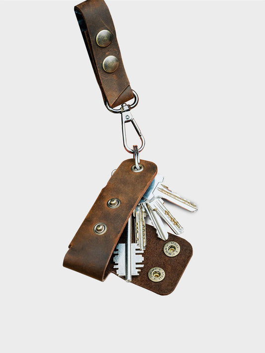 Brown leather key holder with keys on a white background