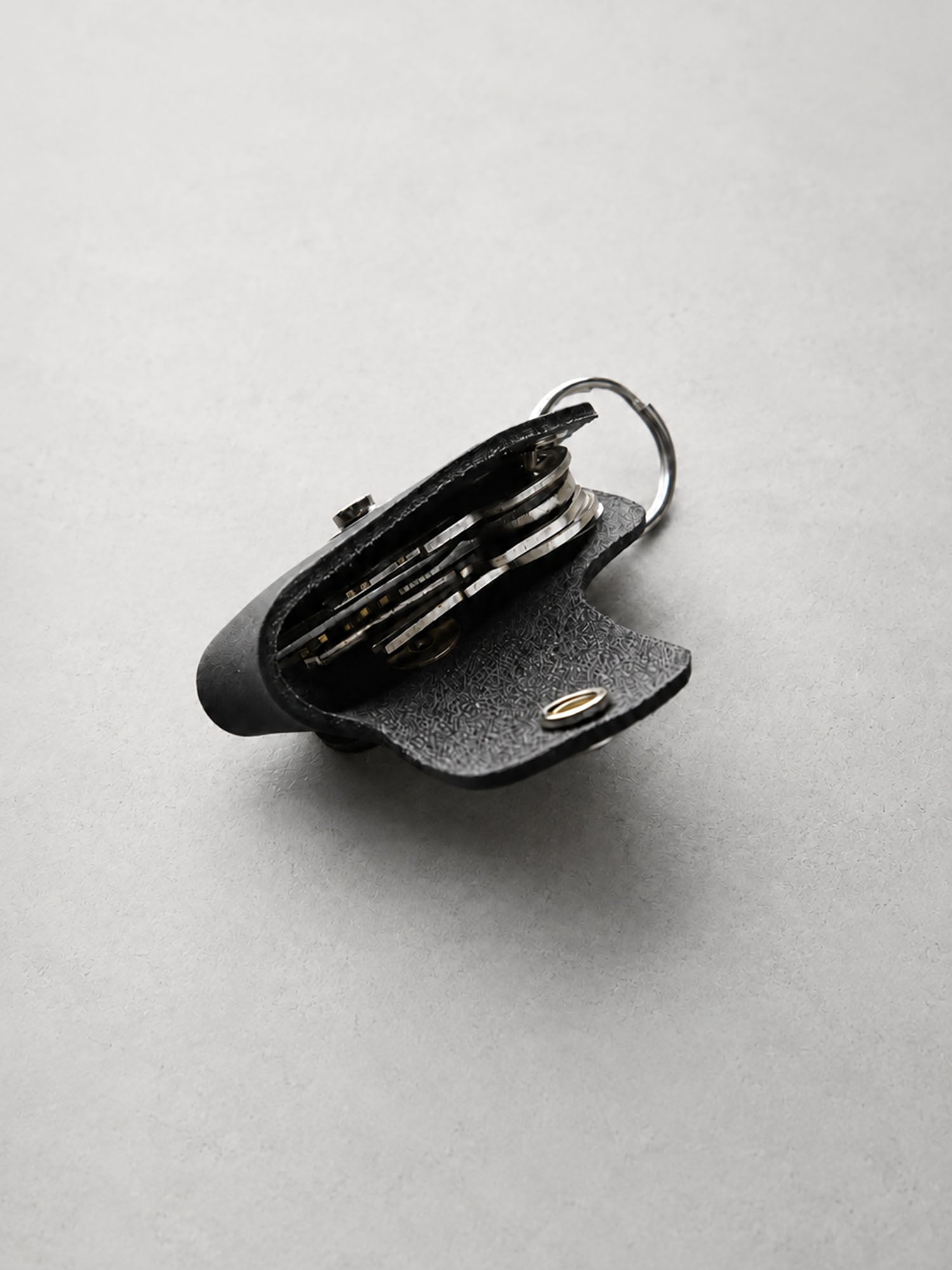 Black leather multi-tool with tools inside on a light gray background