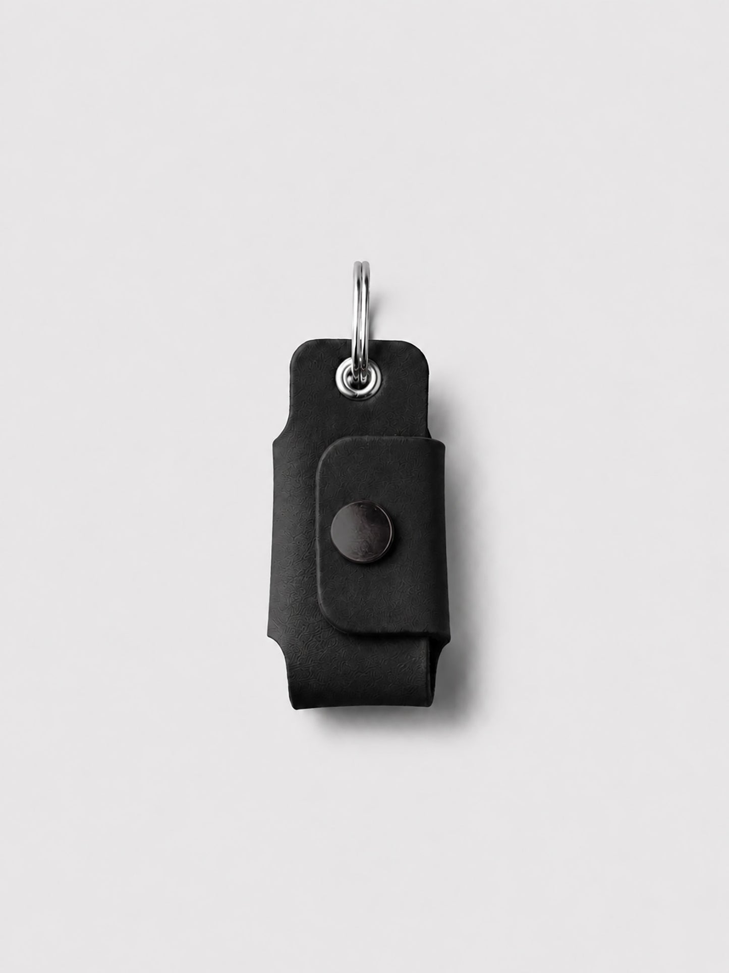 Black key case with a keychain on a light gray background