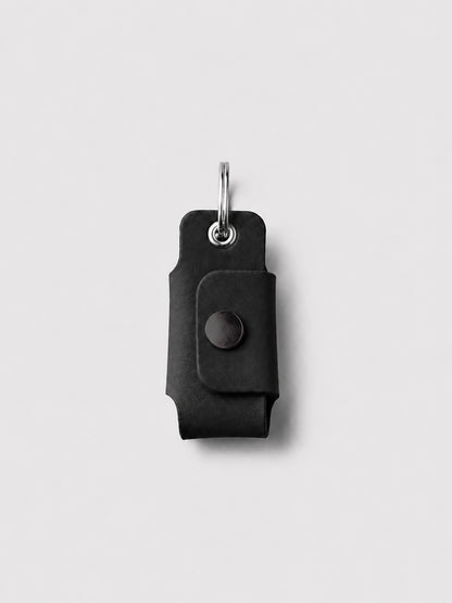 Black key case with a keychain on a light gray background
